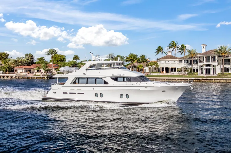 Slide: The Image of Luxurious 2009 Cheoy Lee 78 yacht cruising near waterfront homes under a clear blue sky. - 3