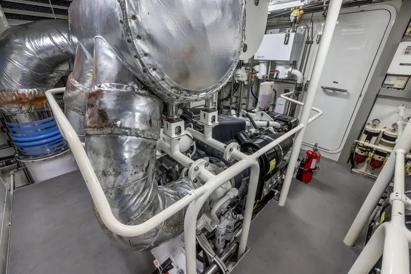 Slide: The Image of Engine room of a 2009 Cheoy Lee 78 yacht, featuring insulated pipes and machinery. - 48