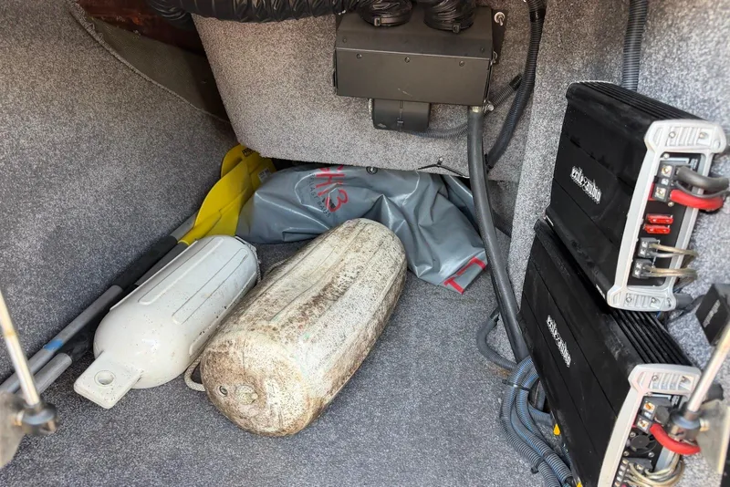 Slide: The Image of 2015 TomCat MB Sports Wake 22 storage area with equipment and audio components. - 20