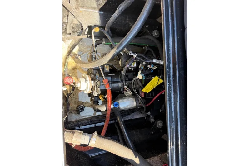Slide: The Image of Engine compartment of a 2015 TomCat MB Sports Wake 22 boat, showing hoses and components. - 9