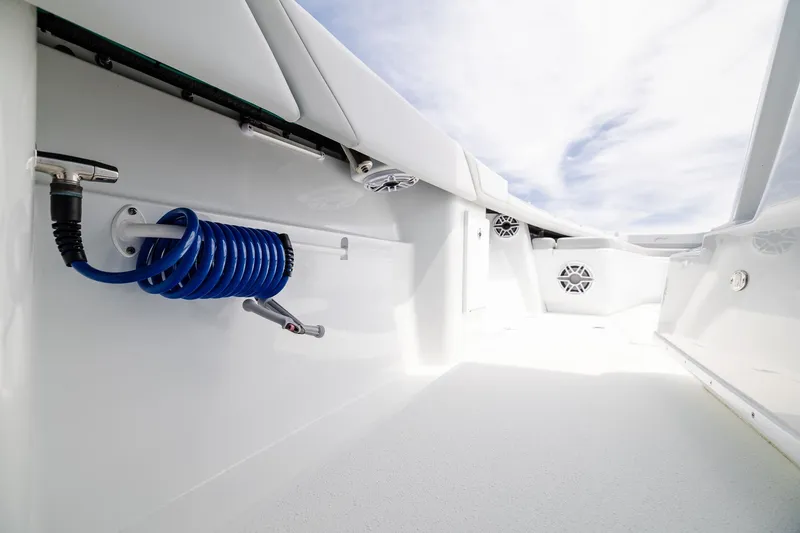 Slide: The Image of 2023 Yellowfin 39 Offshore boat deck with coiled blue hose and sleek white finish. - 18
