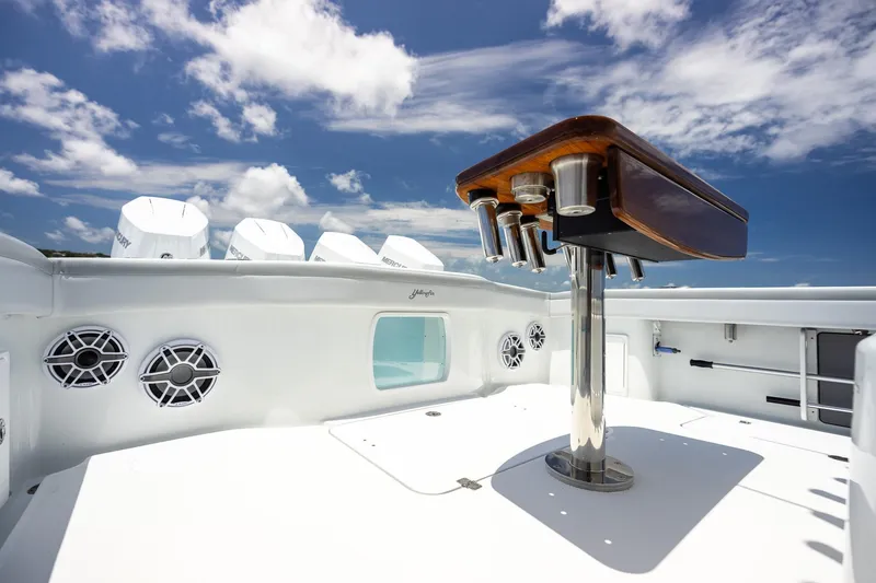 Slide: The Image of 2023 Yellowfin 39 Offshore boat deck with rod holders and speakers under a blue sky. - 43