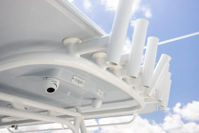 Slide: The Image of 2023 Yellowfin 39 Offshore boat roof with rod holders and camera against blue sky. - 35