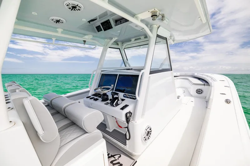 Slide: The Image of 2023 Yellowfin 39 Offshore boat interior with modern helm, set against a serene ocean backdrop. - 23