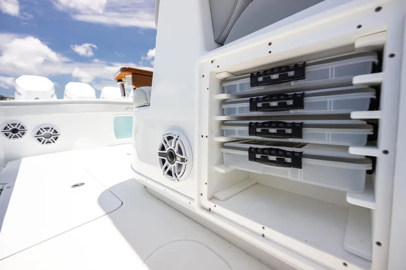 Slide: The Image of 2023 Yellowfin 39 Offshore boat storage compartments and speakers under clear blue sky. - 45