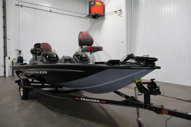 Slide: The Image of 2022 Tracker Pro Team 175 TXW boat in a garage, featuring dual seats and trailer. - 3