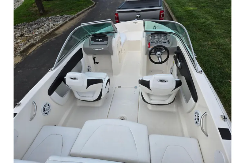 Slide: The Image of 2016 Chaparral 19 H2O Sport boat interior with white seating and steering console. - 10