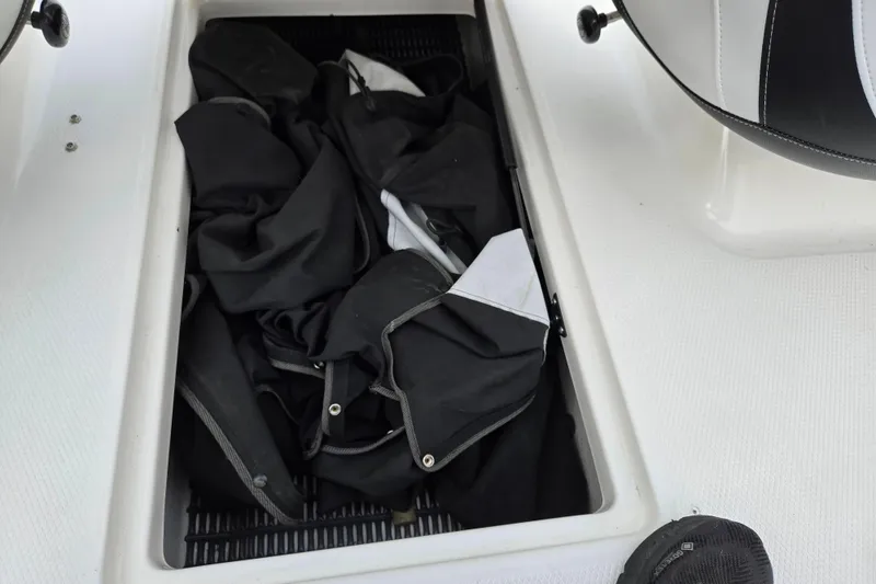 Slide: The Image of Storage compartment in 2016 Chaparral 19 H2O Sport boat with black canvas cover. - 12