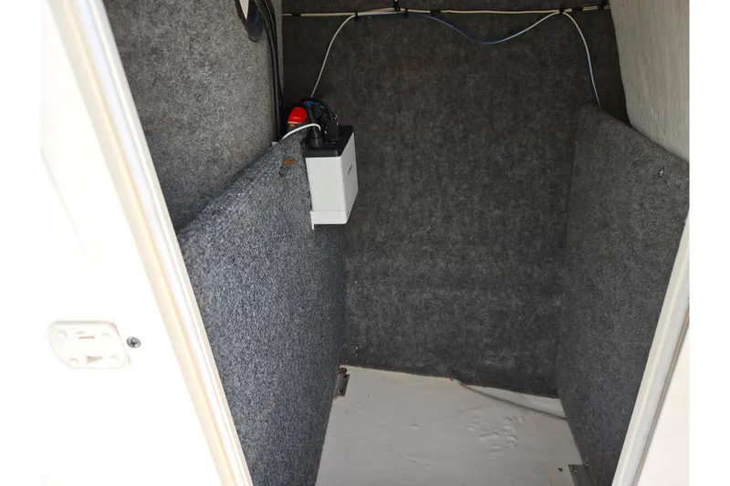 Slide: The Image of Interior storage compartment of 2016 Chaparral 19 H2O Sport boat, featuring carpeted walls. - 16