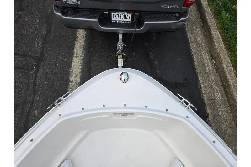 Slide: The Image of 2016 Chaparral 19 H2O Sport boat hitched to a vehicle on a paved road. - 19