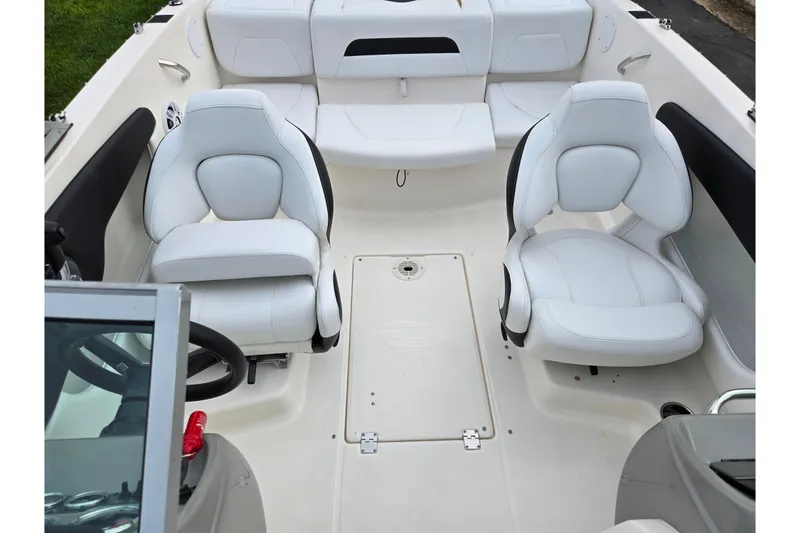 Slide: The Image of 2016 Chaparral 19 H2O Sport boat interior with white seating and steering wheel. - 22