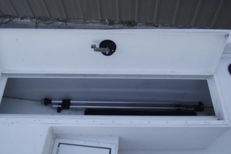 Slide: The Image of Storage compartment of 2023 G3 Bay 20 GX boat, featuring secure latch and metal poles. - 10