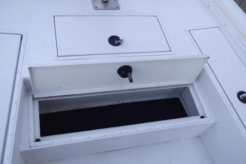 Slide: The Image of 2023 G3 Bay 20 GX boat storage compartments with open hatch and secure locks. - 11