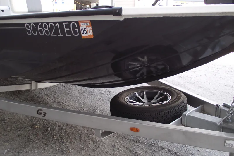 Slide: The Image of 2023 G3 Bay 20 GX boat on trailer, showing registration and spare tire. - 2