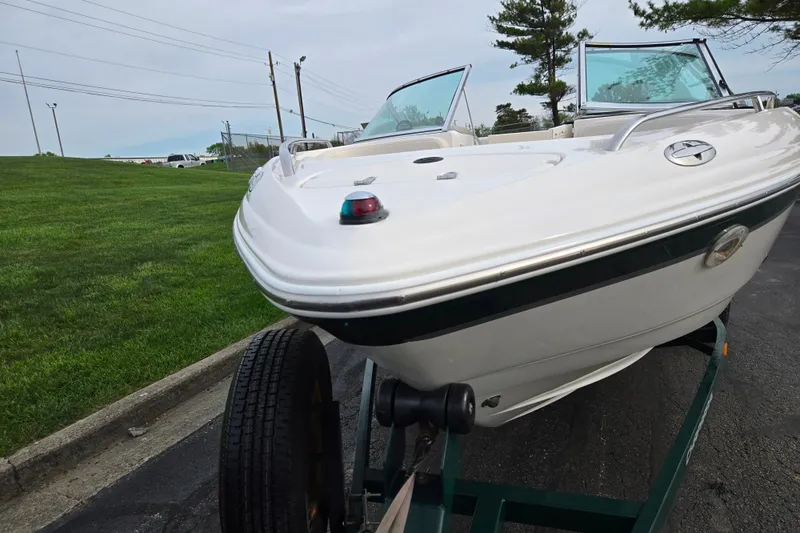 Slide: The Image of 2000 Chaparral 186 SSi boat on trailer, parked on paved road near grassy area. - 6