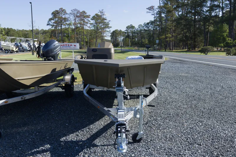 Slide: The Image of 2026 G3 Gator Tough 17 SC boat on trailer, parked on gravel near trees. - 4