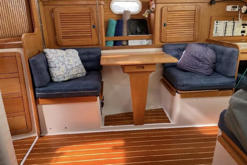 Slide: The Image of Cozy interior of a 2001 Catalina 36 MkII sailboat with wooden accents and cushioned seating. - 11