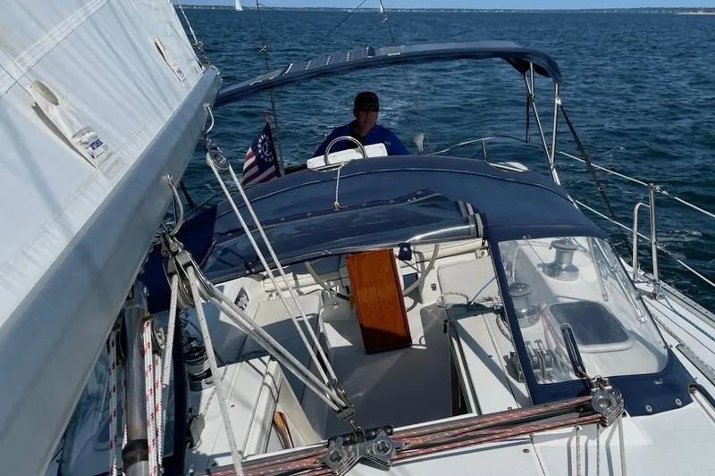 Slide: The Image of Sailing on a 2001 Catalina 36 MkII yacht with blue canopy and American flag. - 4