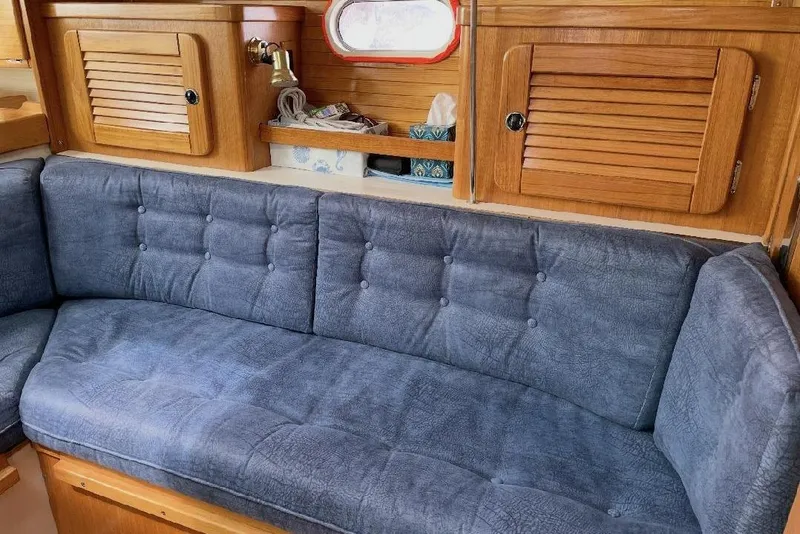 Slide: The Image of Interior of 2001 Catalina 36 MkII sailboat with blue cushioned seating and wooden cabinetry. - 9