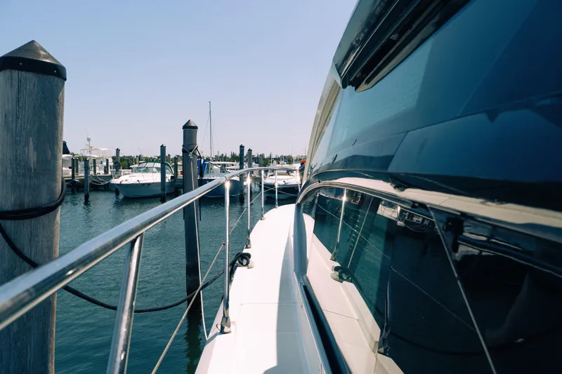 Slide: The Image of 2019 Beneteau Gran Turismo 50 yacht docked at marina, reflecting sunlight on water. - 15