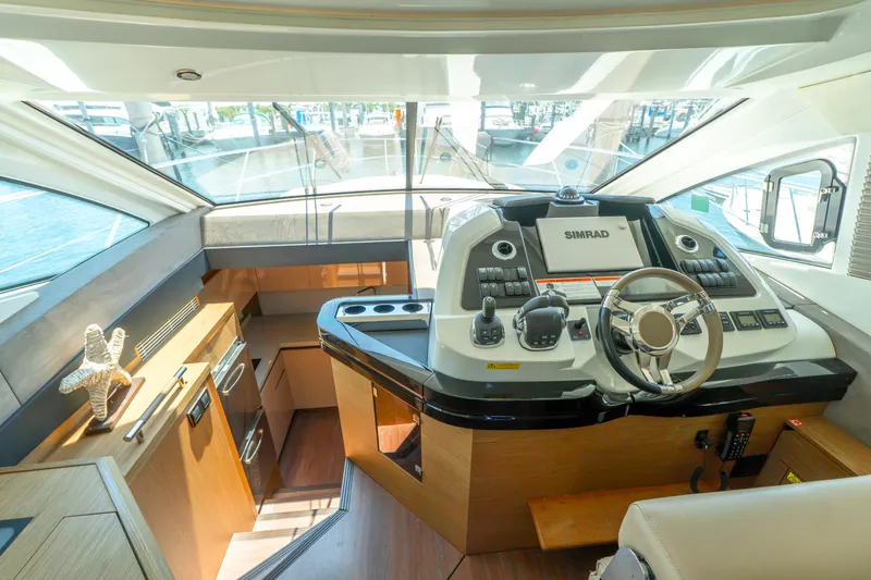 Slide: The Image of Helm station of 2019 Beneteau Gran Turismo 50 yacht with modern controls and navigation equipment. - 2