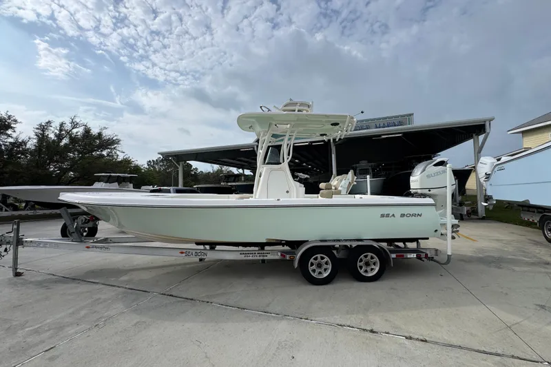 The Image of 2019 Sea Born FX25 Bay boat on trailer, parked outdoors under cloudy sky. - 1