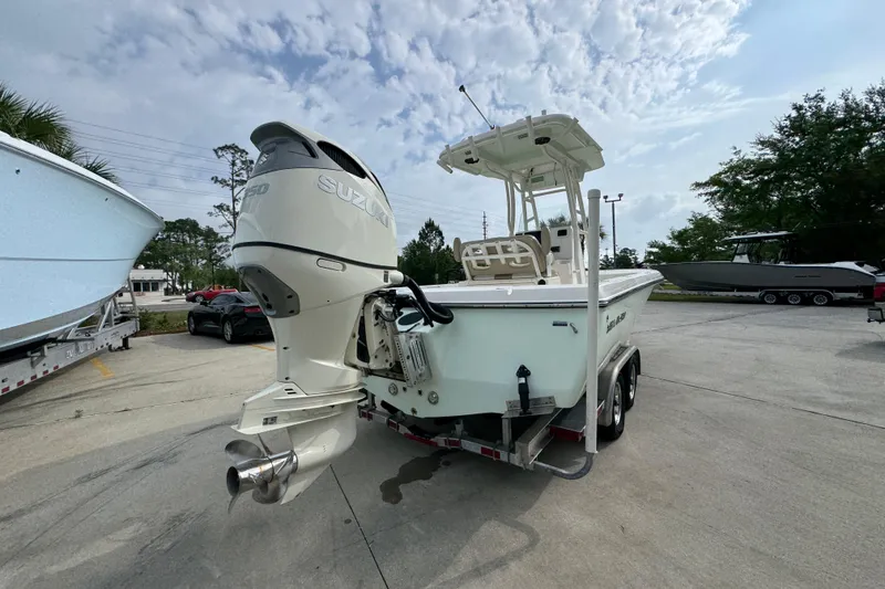 Slide: The Image of 2019 Sea Born FX25 Bay boat with Suzuki outboard motor on trailer, parked outdoors. - 13