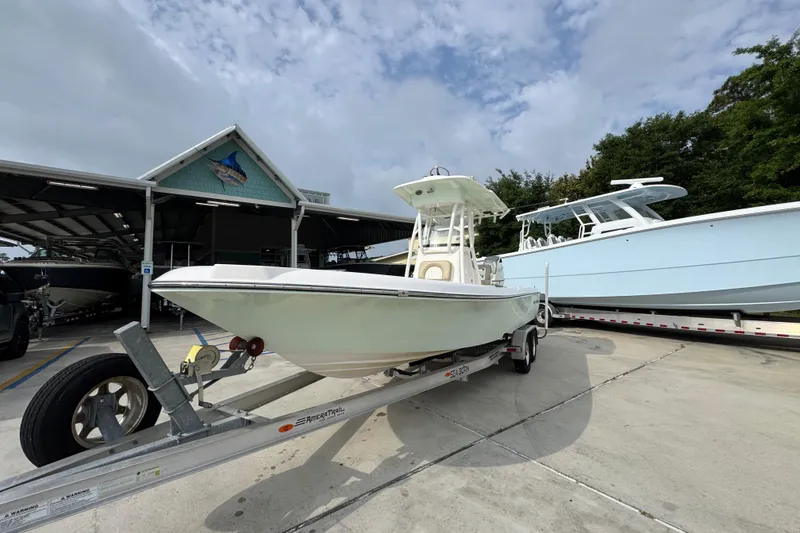 Slide: The Image of 2019 Sea Born FX25 Bay boat on trailer at marina, under cloudy sky. - 4