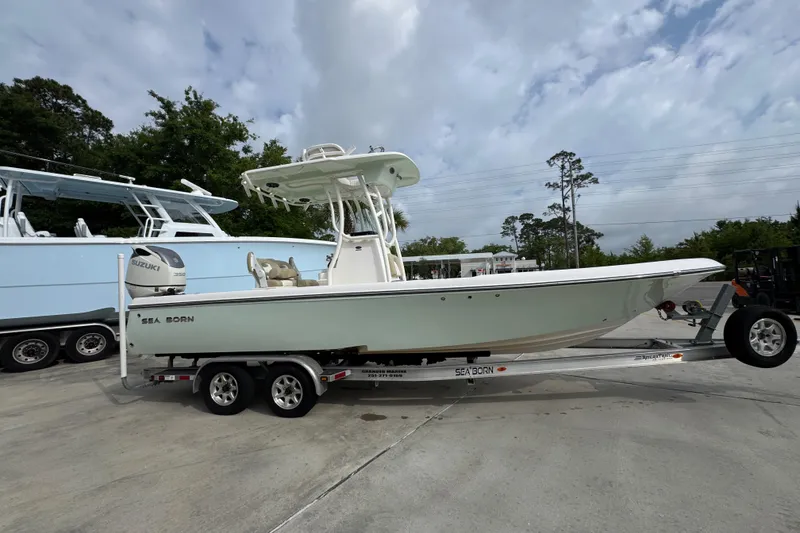 Slide: The Image of 2019 Sea Born FX25 Bay boat on trailer, parked outdoors under cloudy sky. - 9