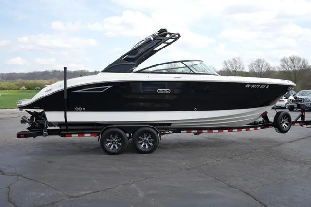 Slide: The Image of 2025 Sea Ray SDX 270 boat on trailer, black and white design, parked outdoors. - 4