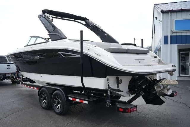 Slide: The Image of 2025 Sea Ray SDX 270 boat on trailer, black and white exterior, parked outside. - 7
