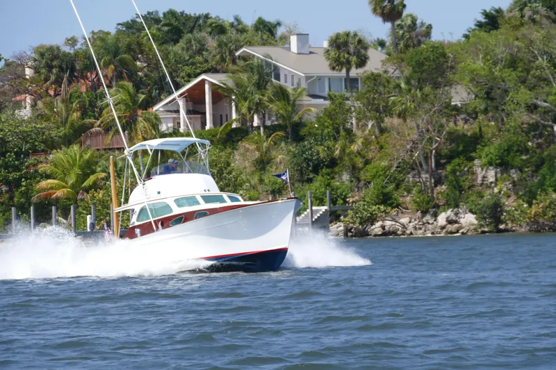 Slide: The Image of 1949 Rybovich Sport Fish boat cruising near a lush shoreline. - 1
