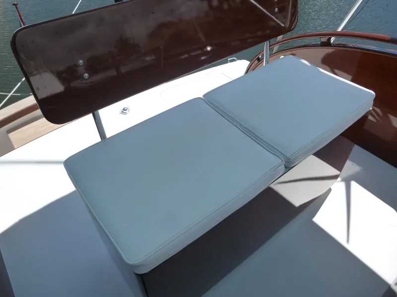 Slide: The Image of 1949 Rybovich Sport Fish boat seating with white cushions and wooden accents. - 12