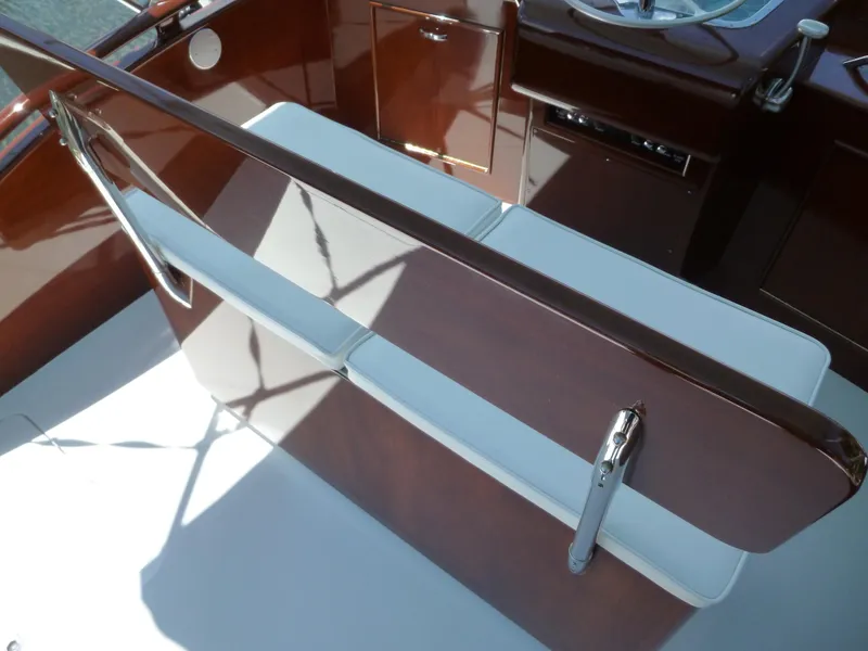 Slide: The Image of 1949 Rybovich Sport Fish boat interior with polished wood and white seating. - 13