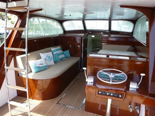 Slide: The Image of 1949 Rybovich Sport Fish boat interior with polished wood and nautical-themed cushions. - 18