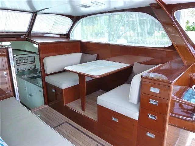 Slide: The Image of 1949 Rybovich Sport Fish interior with wooden finish and cushioned seating. - 19