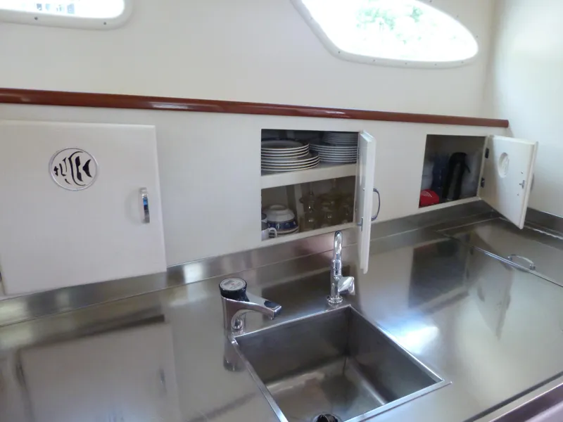 Slide: The Image of 1949 Rybovich Sport Fish boat kitchen with stainless steel sink and storage cabinets. - 31