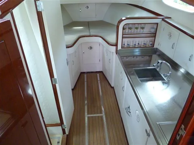 Slide: The Image of 1949 Rybovich Sport Fish yacht interior with wooden flooring and compact kitchen area. - 34