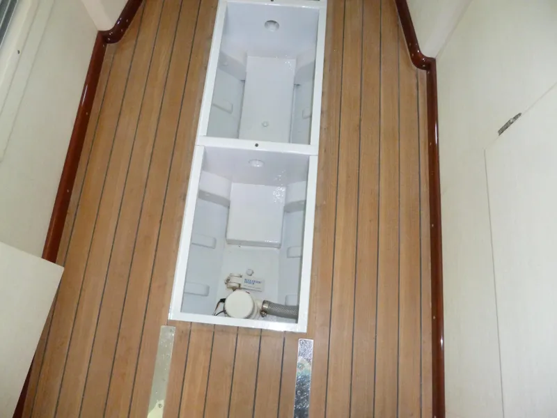 Slide: The Image of 1949 Rybovich Sport Fish boat interior with wooden flooring and storage compartments. - 37