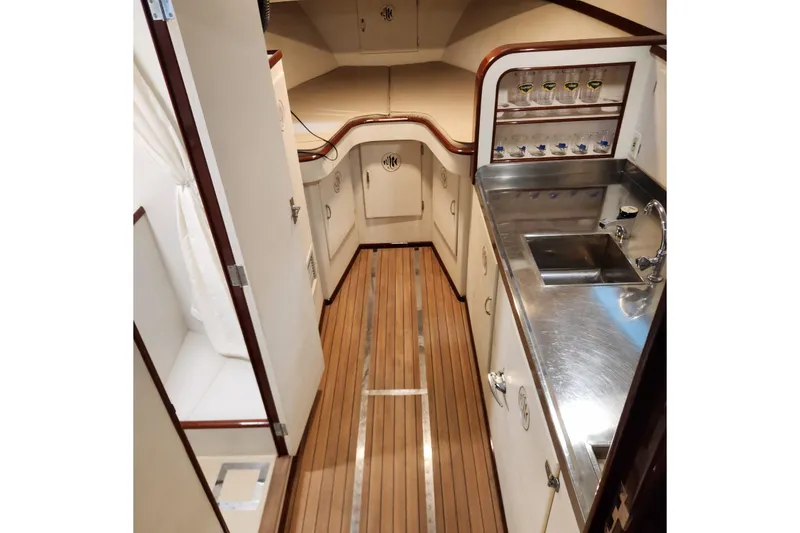 Slide: The Image of 1949 Rybovich Sport Fish boat interior with wooden flooring and stainless steel sink. - 55