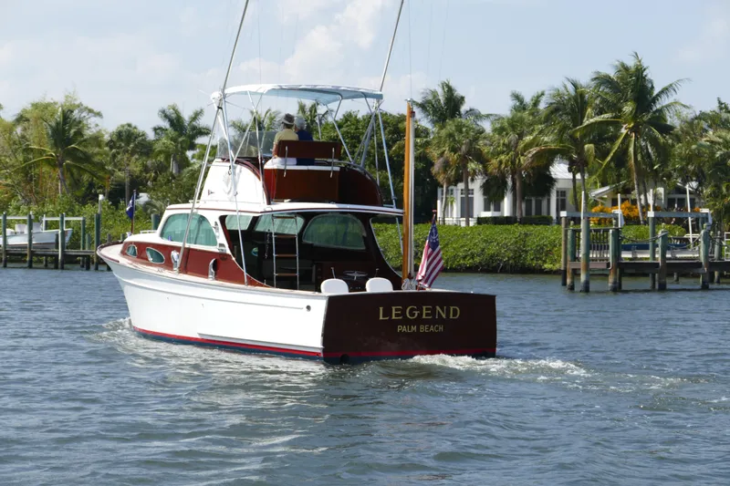 Slide: The Image of 1949 Rybovich Sport Fish boat cruising near palm trees and docks. - 7