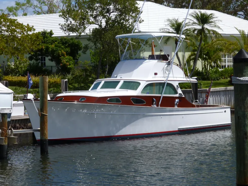 Slide: The Image of 1949 Rybovich Sport Fish boat docked in a scenic marina setting. - 8