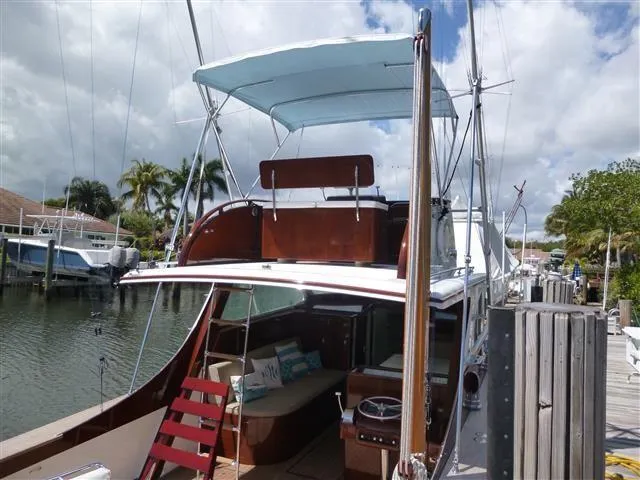 Slide: The Image of 1949 Rybovich Sport Fish boat docked, featuring a blue canopy and wooden deck. - 9