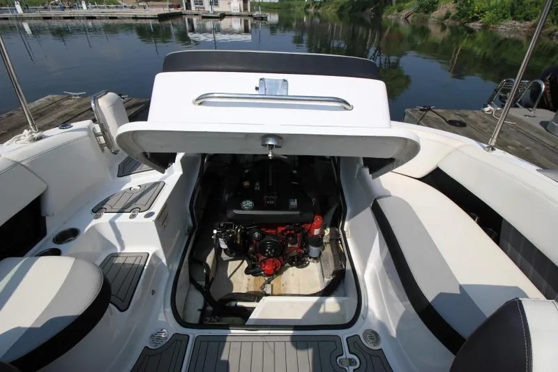 Slide: The Image of 2015 Cruisers Sport Series 238 Bow Rider engine compartment open by the water. - 20