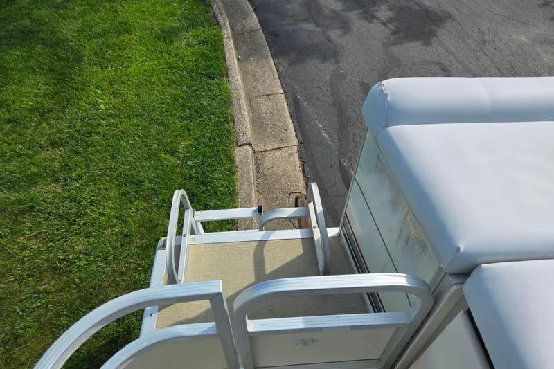 Slide: The Image of Pontoon boat Bennington 2275LX (1999) parked on grass beside a curb. - 17