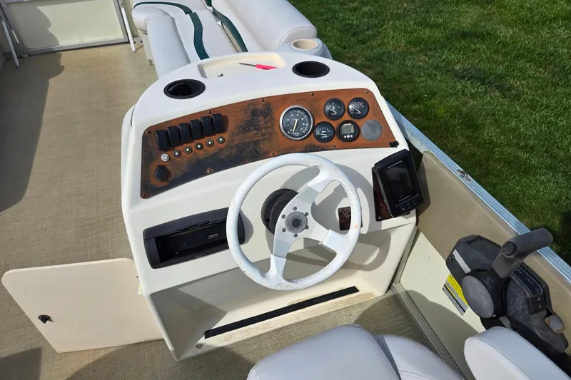 Slide: The Image of 1999 Bennington 2275LX boat dashboard with steering wheel and control panel. - 21