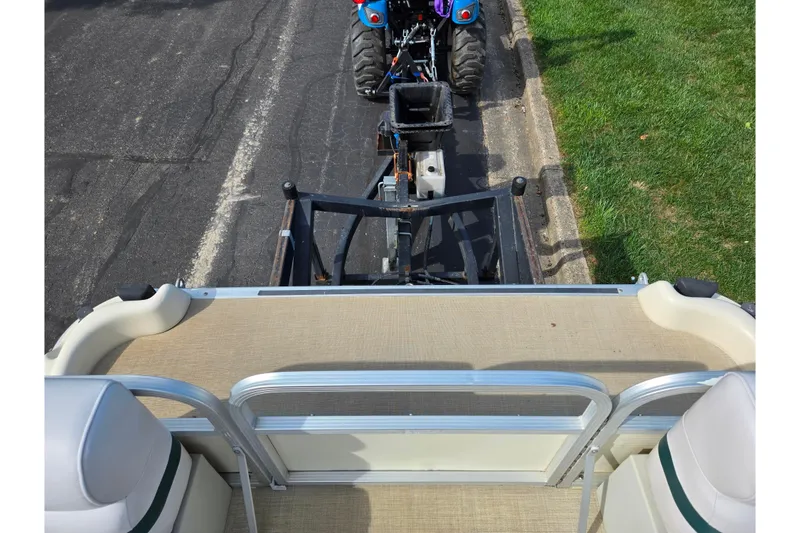 Slide: The Image of 1999 Bennington 2275LX pontoon boat hitched to a tractor on a paved road. - 23