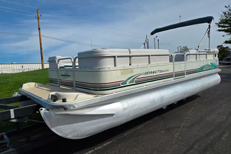 Slide: The Image of 1999 Bennington 2275LX pontoon boat on trailer, featuring green and white design. - 5