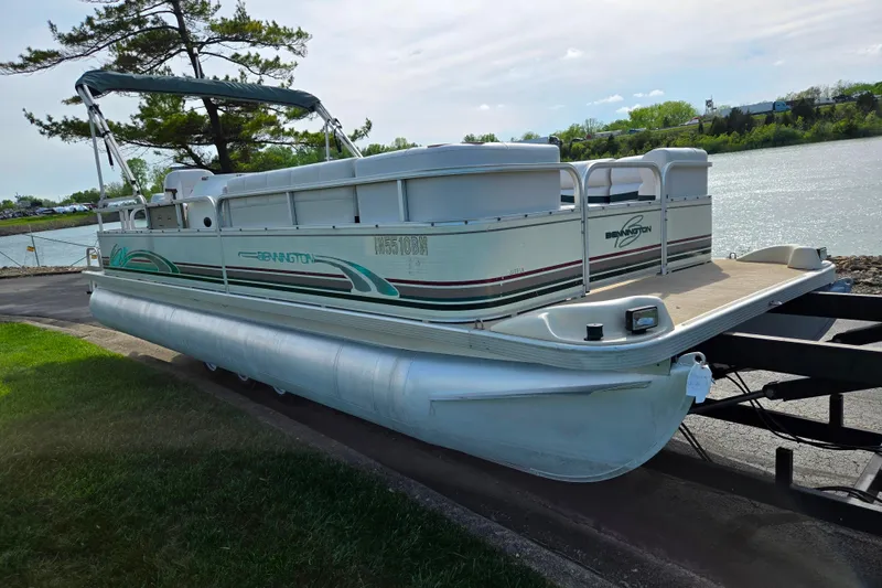 Slide: The Image of 1999 Bennington 2275LX pontoon boat on trailer by a lakeside. - 8