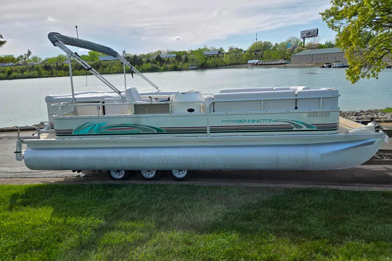 Slide: The Image of 1999 Bennington 2275LX pontoon boat on trailer by a scenic lakeside. - 9